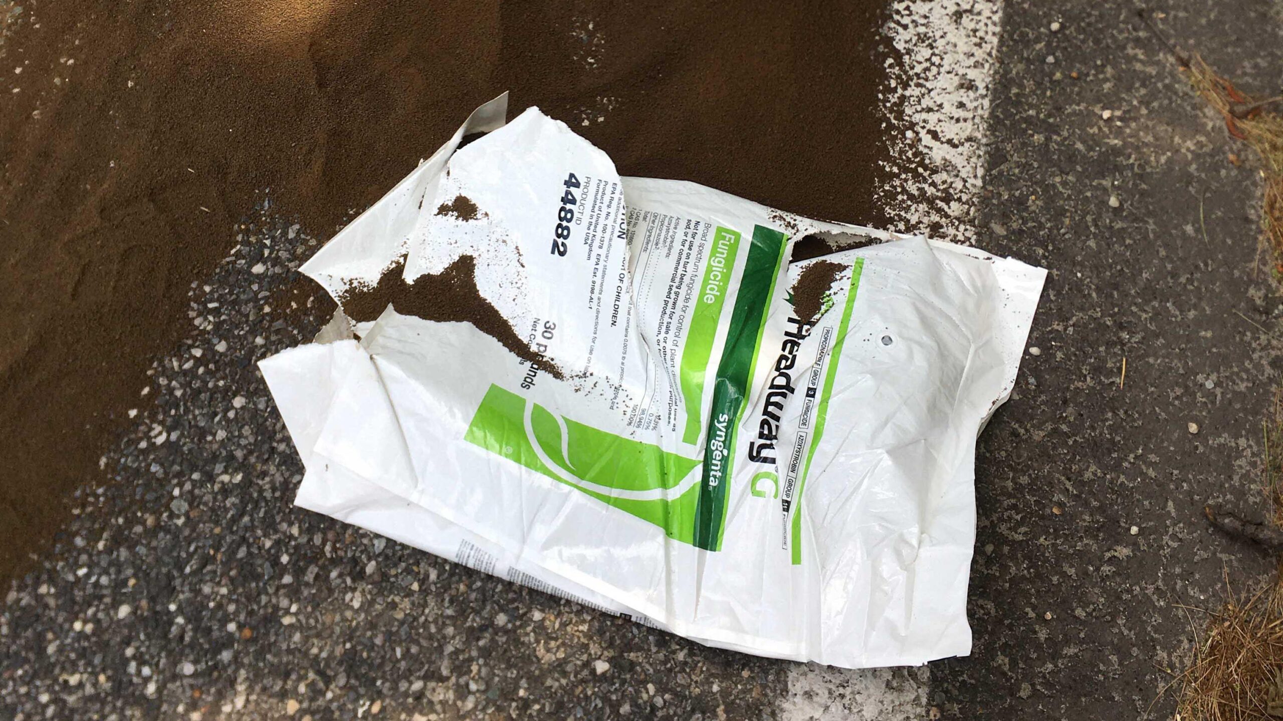 ripped bag of fungicide on the road